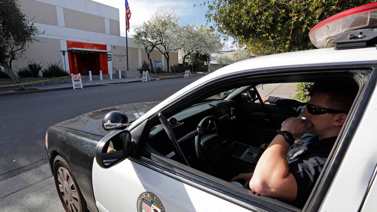 Officers in a patrol car keep watch in front of the West Los Angeles police station, Friday, Feb. 8, 2013.(AP Photo/Reed Saxon)