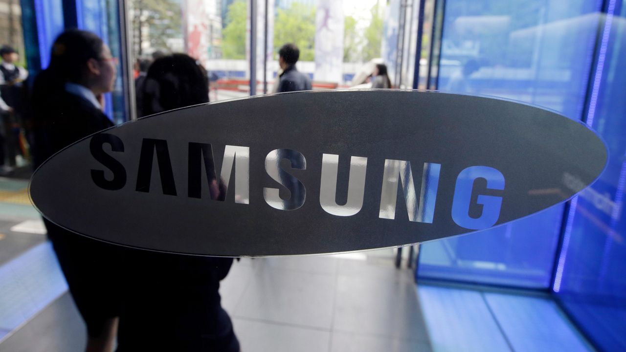In this April 29, 2015 file photo, visitors walk by the logo of Samsung Electronics Co. at its showroom in Seoul, South Korea. (AP Photo/Lee Jin-man, File)