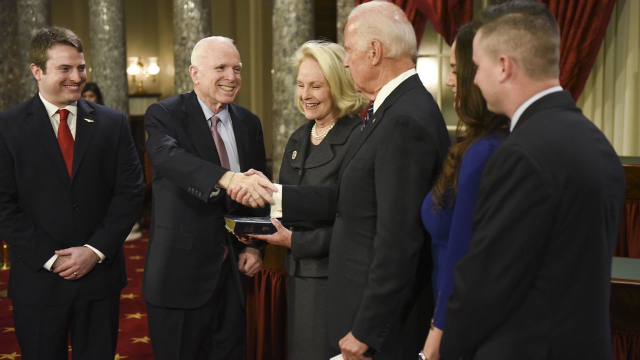 Vice President Joe Biden administers the Senate oath of office to Sen. John McCain, R-Ariz., accompanied by his wife, Cindy McCain, holding bible, and his family look on during a a mock swearing in ceremony in the Old Senate Chamber on Capitol Hill in Washington, Tuesday, Jan. 3, 2017. (AP Photo/Kevin Wolf)