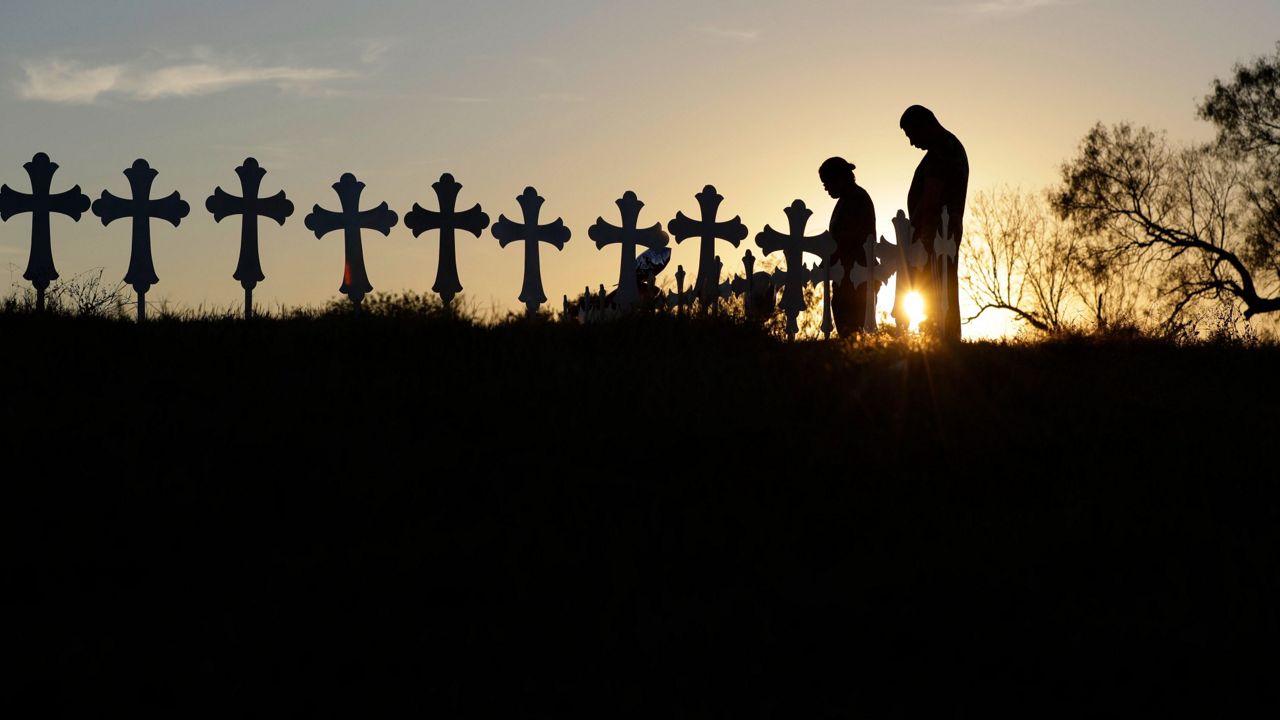 Kenneth and Irene Hernandez pay their respects as they visit a makeshift memorial with crosses placed near the scene of a shooting at the First Baptist Church of Sutherland Springs, Monday, Nov. 6, 2017, in Sutherland Springs, Texas. (AP Photo/Eric Gay)