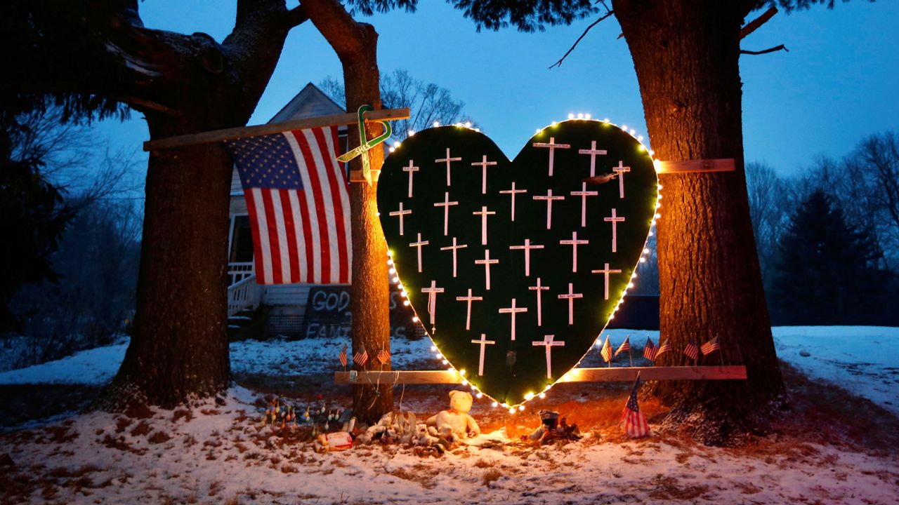FILE - In this Dec. 14, 2013, file photo, a makeshift memorial with crosses for the victims of the Sandy Hook Elementary School shooting massacre stands outside a home on the first anniversary of the tragedy in Newtown, Conn. (AP Photo/Robert F. Bukaty, File)