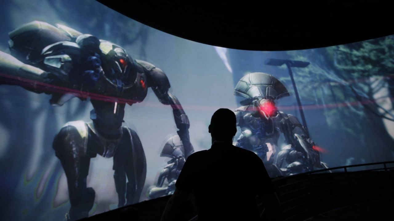 In this June 13, 2013, file photo, Alex Beckers watches a presentation on the video game "Destiny" at the Activision Blizzard Booth during the Electronic Entertainment Expo in Los Angeles. (AP Photo/Jae C. Hong)