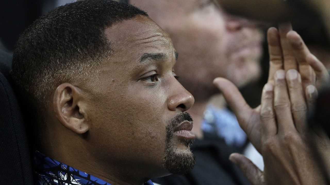 U.S. actor Will Smith, left, watches the third round match between France's Jo-Wilfried Tsonga and Australia's Nick Kyrgios at the Australian Open tennis championships in Melbourne, Australia, Friday, Jan. 19, 2018. (AP Photo/Dita Alangkara)