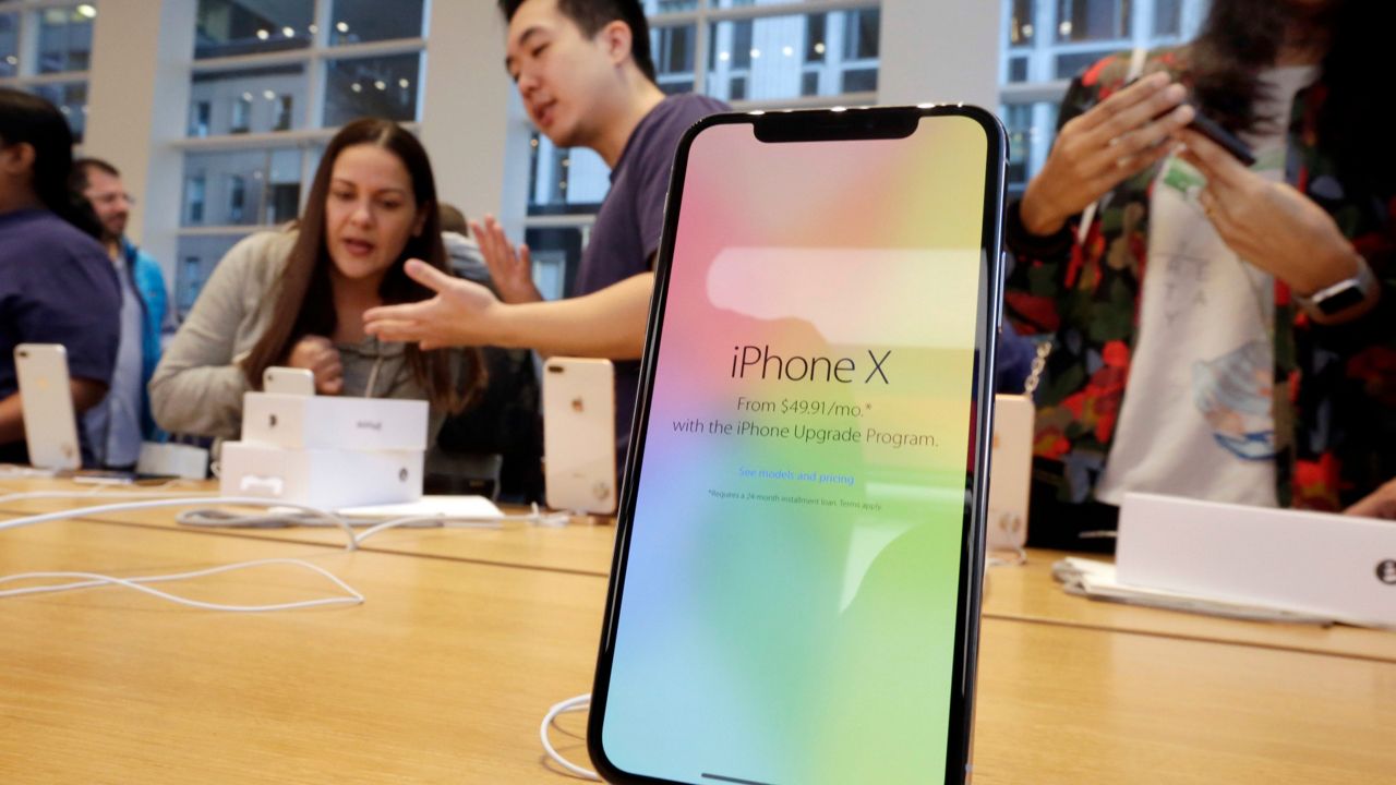 In this Friday, Nov. 3, 2017, file photo, customers buy the iPhone X at the Apple Store on New York's Fifth Avenue. (AP Photo/Richard Drew, File)