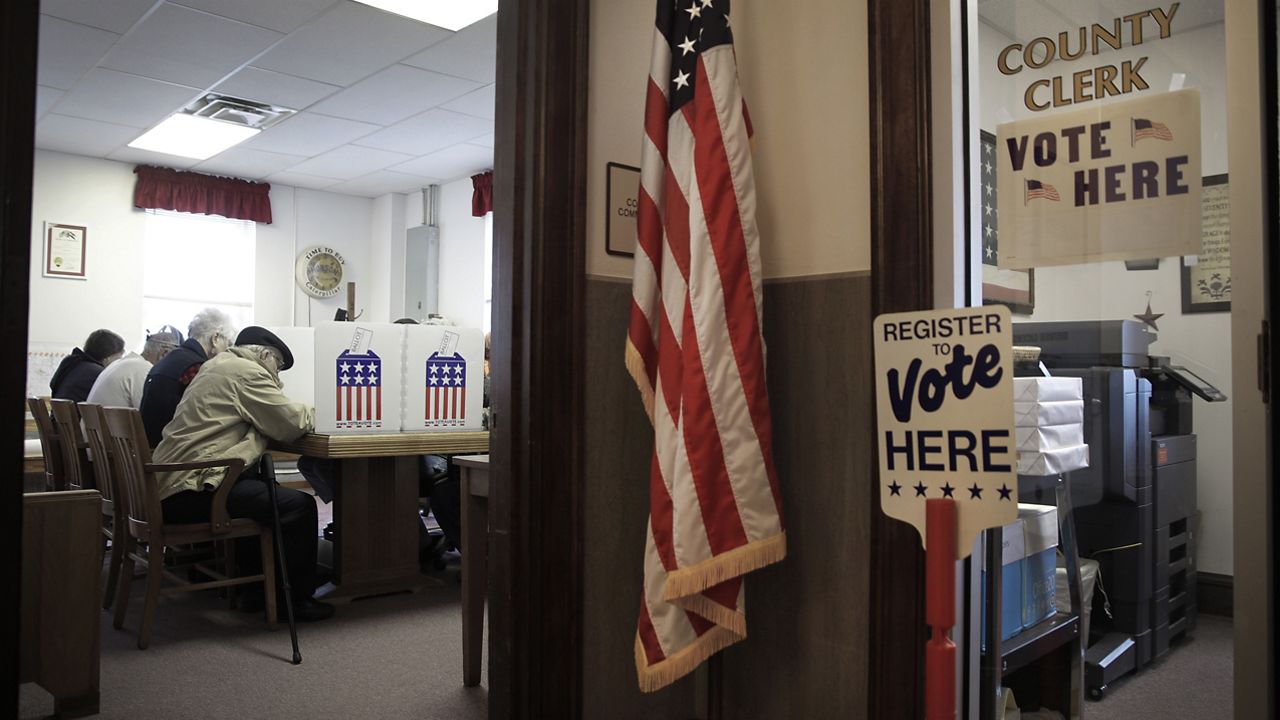 FILE PHOTO - People vote in the county commission chambers at the Cedar County Courthouse Tuesday, Nov. 6, 2018, in Stockton, Mo. (AP Photo/Charlie Riedel)