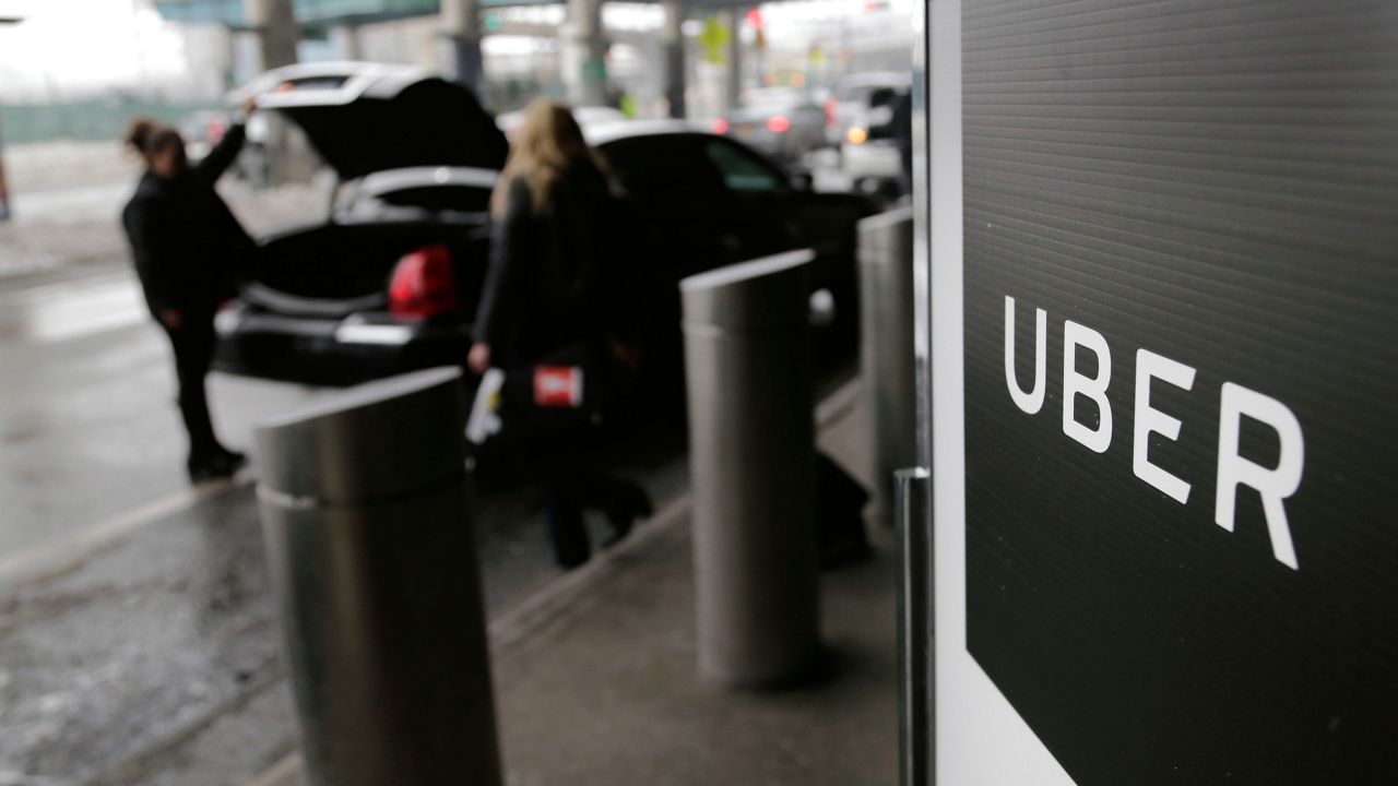FILE - In this March 15, 2017, file photo, a sign marks a pick up point for the Uber car service at LaGuardia Airport in New York. (AP Photo/Seth Wenig, File)