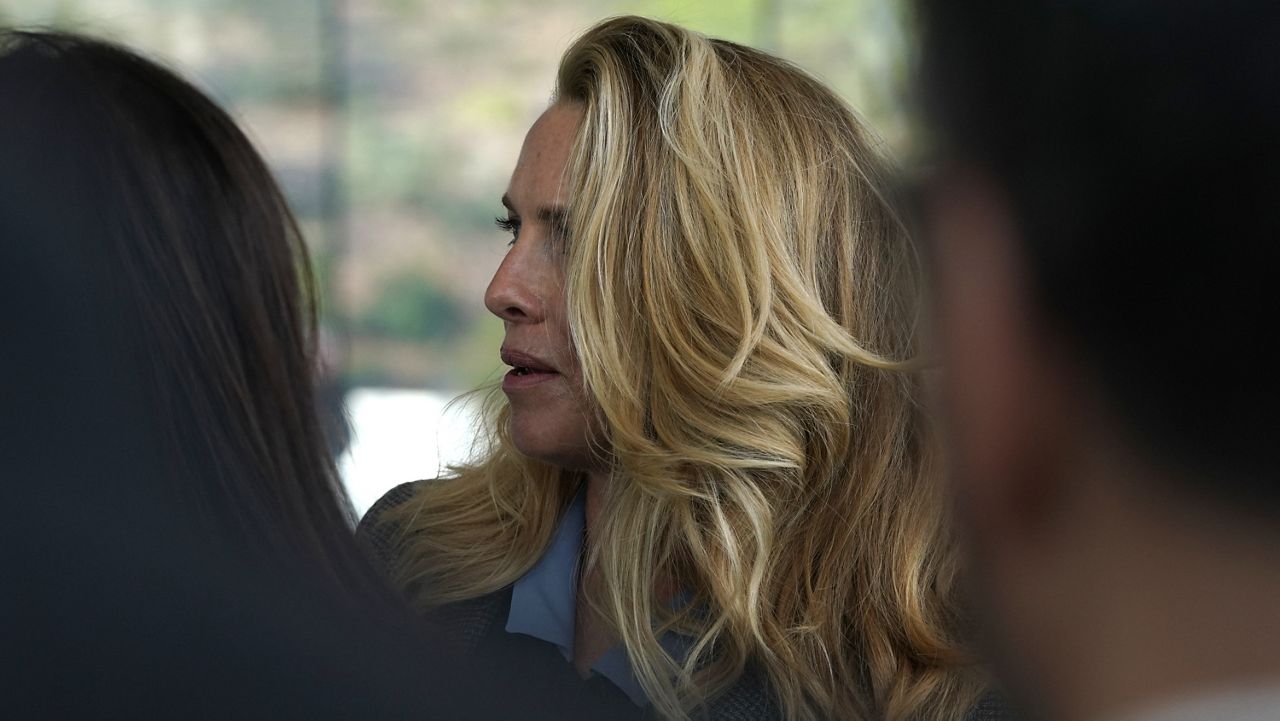 Laurene Powell, the widow of Steve Jobs, waits to enter the Steve Jobs Theater for an event to announce new products Monday, March. 25, 2019, in Cupertino, Calif. (AP Photo/Tony Avelar)