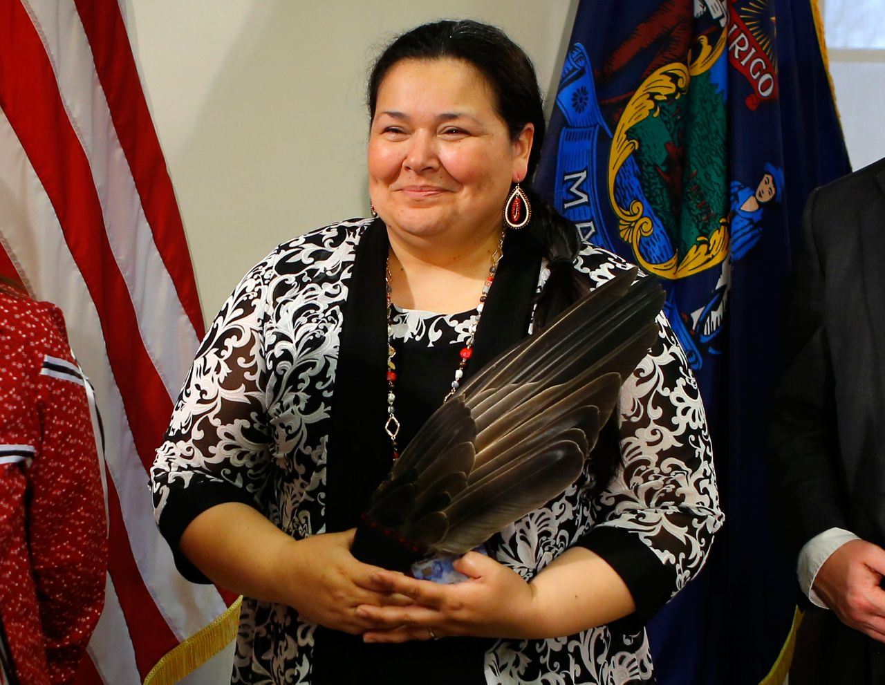 Clarissa Sabattus, Tribal Chief of the Houlton Band of Maliseet Indians, holds eagle feathers during the signing ceremony to establish Indigenous Peoples' Day, Friday, April 26, 2019, at the State House in Augusta, Maine. Gov. Janet Mills signed the bill, adding Maine to the growing number of states who have passed similar legislation. (AP Photo/Robert F. Bukaty)