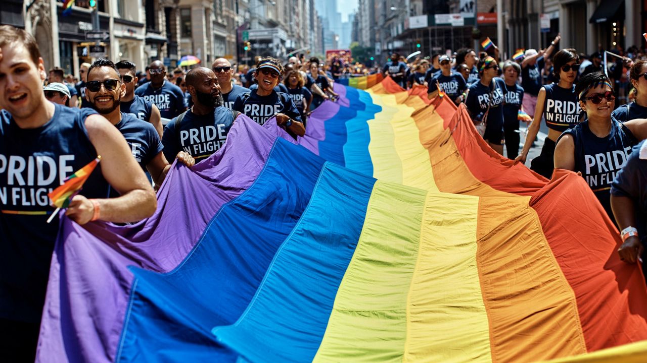 Revelers carry a LGBTQ flag along Fifth Avenue during the New York City Pride Parade in New York. 