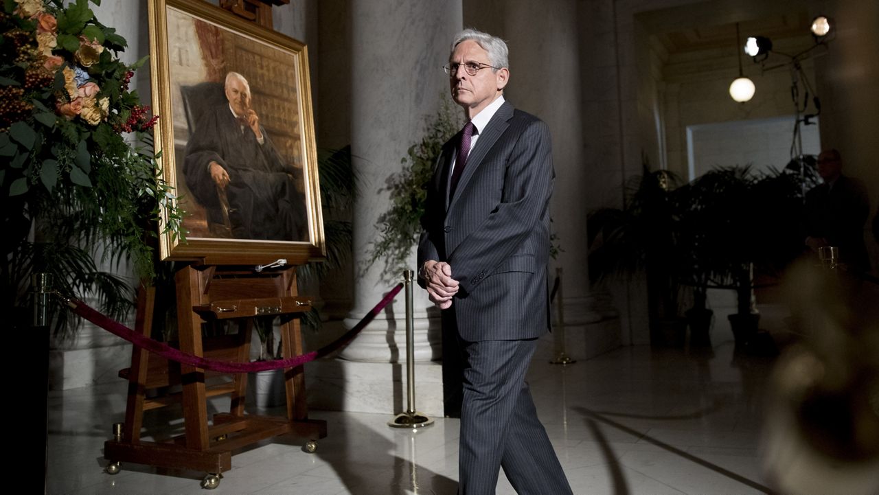 Former President Barack Obama's Supreme Court nominee Merrick Garland walks past a painting of the late Supreme Court Justice John Paul Stevens while paying his respects as Stevens lies in repose in the Great Hall of the Supreme Court in Washington, Monday, July 22, 2019. (AP Photo/Andrew Harnik)