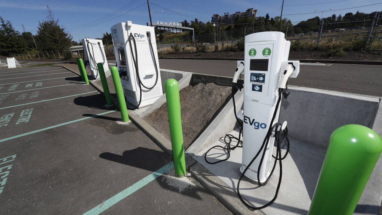 In this July 21, 2019 file photo, electric car charging stations stand along Interstate 5 outside the LeMay Auto Museum in Tacoma, Wash. (AP Photo/David Zalubowski)