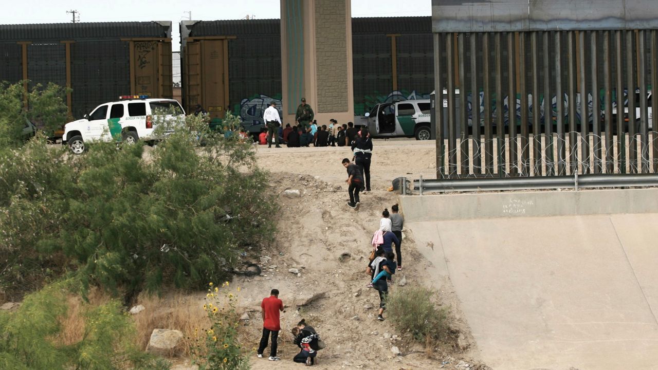 FILE - In this June 15, 2019, file photo, migrants cross the Rio Bravo illegally to surrender to the American authorities on the US - Mexico border between Ciudad Juarez and El Paso. (AP Photo/ Photo/Christian Torres, File)