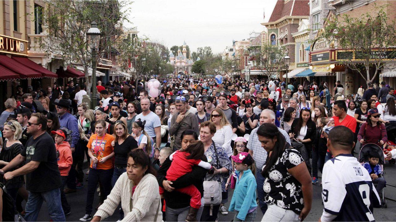 In this Jan. 22, 2015, file photo, people crowd Main Street at Disneyland in Anaheim, Calif. (AP Photo/Jae C. Hong)