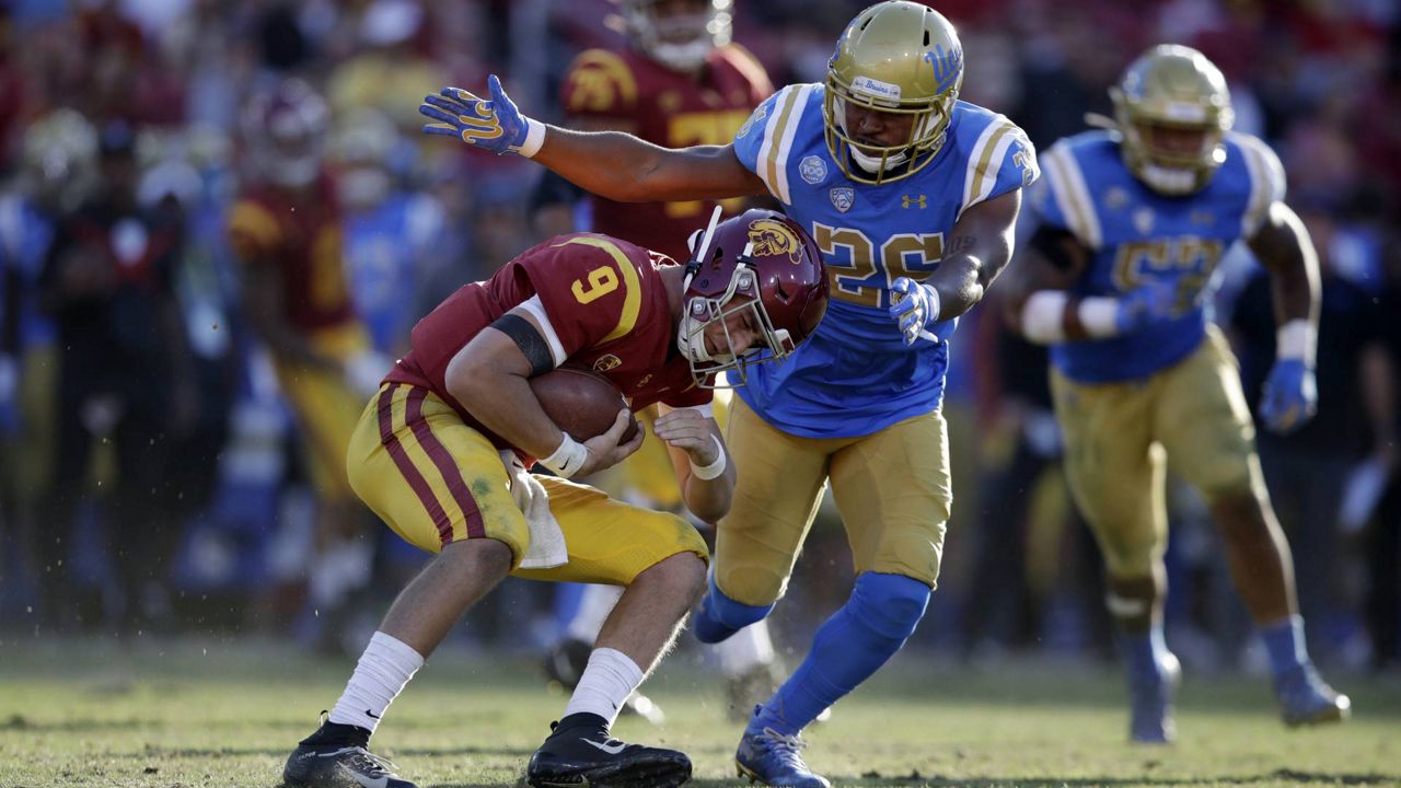 FILE - USC quarterback Kedon Slovis (9) is tackled by UCLA linebacker Leni Toailoa (26) during an NCAA college football game Nov. 23, 2019, in Los Angeles. (AP/Marcio Jose Sanchez)