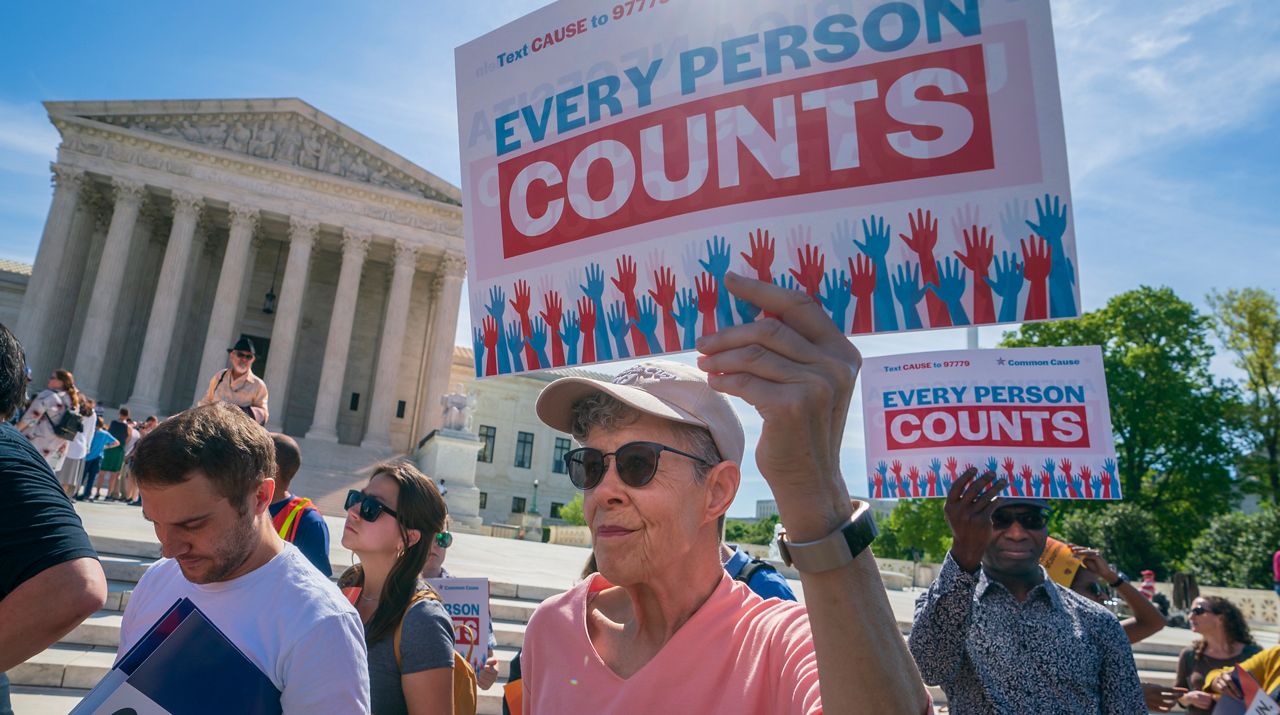 In this April 23, 2019 file photo, immigration activists rally outside the Supreme Court as the justices hear arguments over the Trump administration's plan to ask about citizenship on the 2020 census, in Washington. (AP Photo/J. Scott Applewhite)