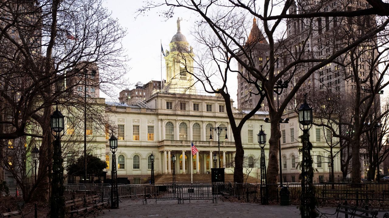 Exterior of New York City Hall, center, and the Municipal Building, right, are shown, Thursday, Jan. 9, 2020 in New York. Shaded trees are in the foreground of the photo.