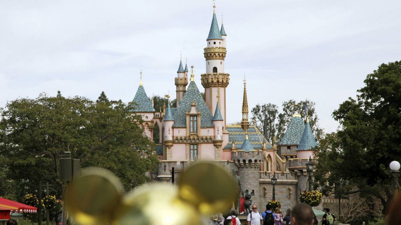 In this Jan. 22, 2015 photo, visitors walk toward Sleeping Beauty's Castle in the background at Disneyland Resort in Anaheim, Calif. (AP/Jae C. Hong)