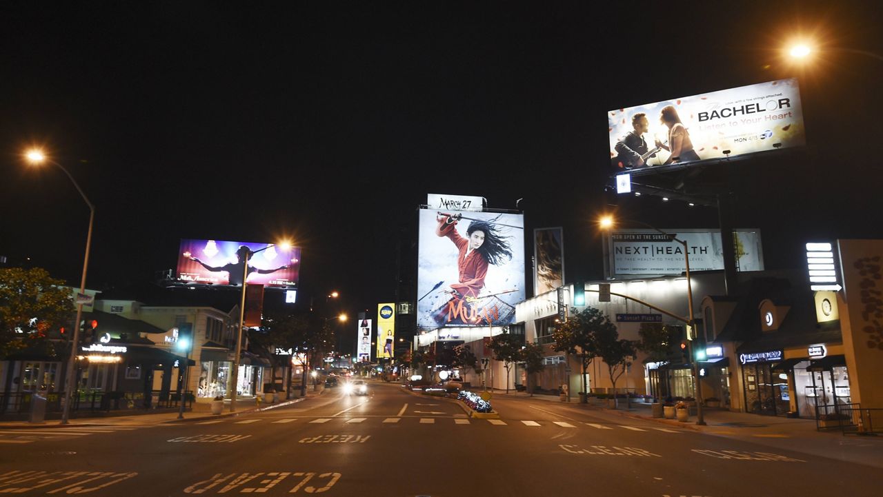 The Sunset Strip is bereft of cars and pedestrians at night as stay-at-home orders continue in California due to the coronavirus outbreak, Wednesday, April 1, 2020, in West Hollywood, Calif. (AP Photo/Chris Pizzello)