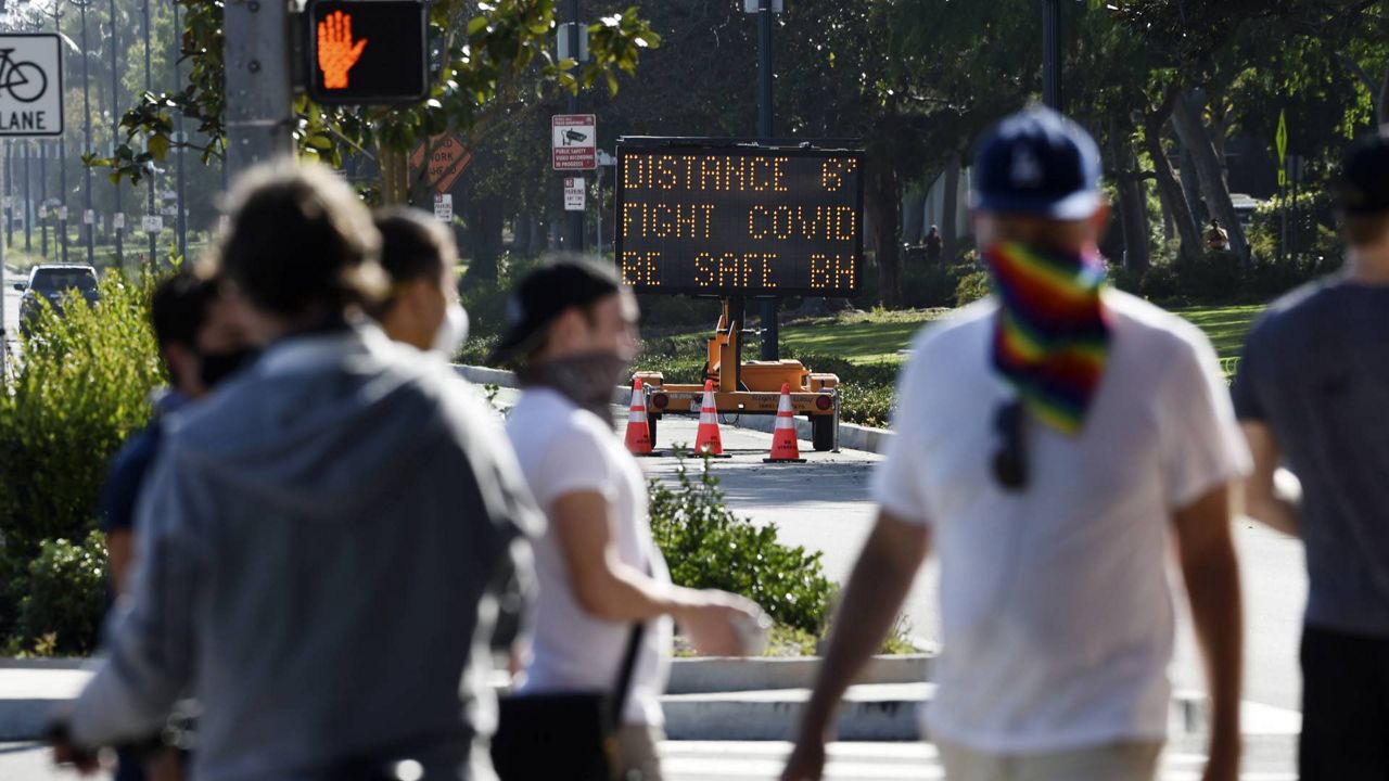 An electronic sign on Santa Monica Blvd. reminds drivers and pedestrians to maintain social distance Thursday, April 16, 2020, in Beverly Hills, Calif. (AP Photo/Chris Pizzello)