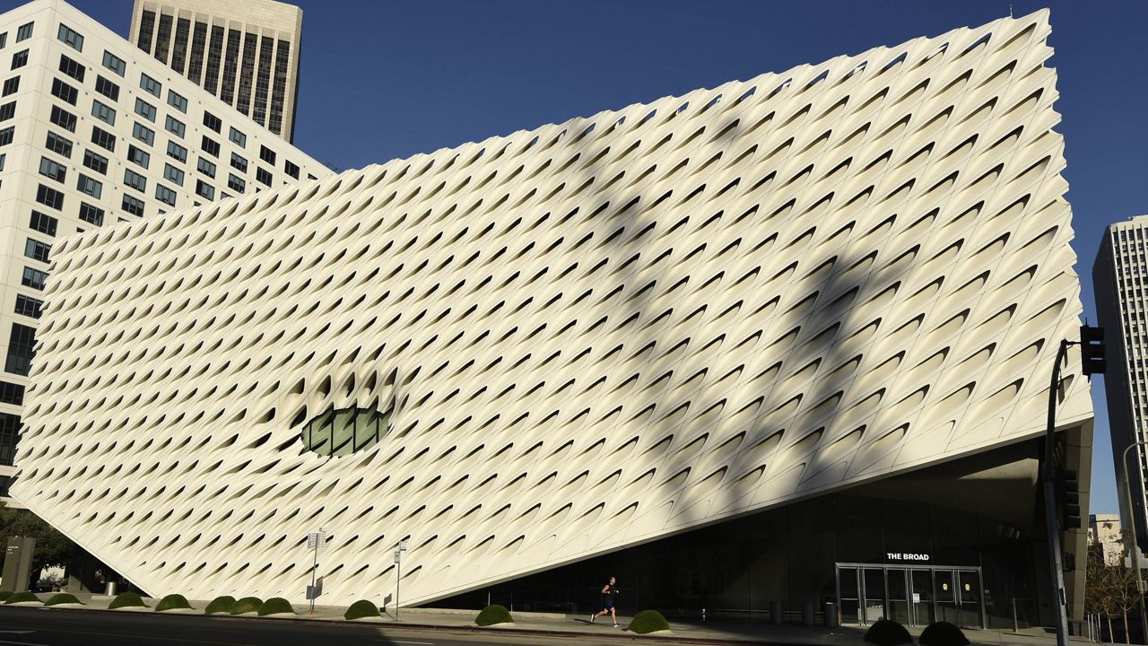 A jogger runs past the Broad Museum on deserted Grand Avenue in Los Angeles as stay-at-home orders continue in California due to the coronavirus pandemic, Saturday, April 25, 2020. (AP Photo/Chris Pizzello)