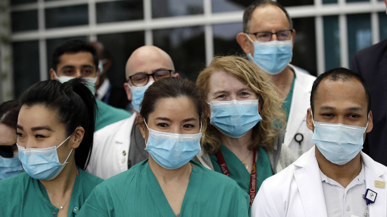 In this April 17, 2020 photo, hospital personnel stand outside Providence St. John's Medical Center in Santa Monica, Calif. (AP Photo/Marcio Jose Sanchez)