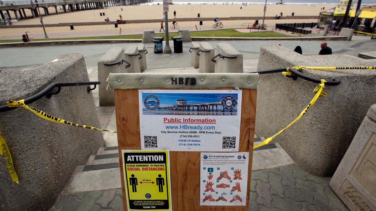 A sign gives social distance and hand washing guidelines Thursday, April 30, 2020, in Huntington Beach, Calif. (AP Photo/Marcio Jose Sanchez)