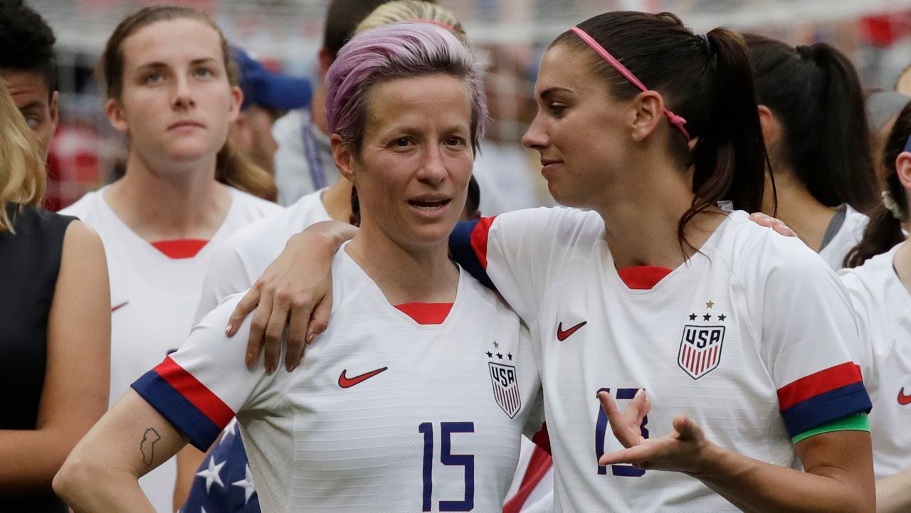 FILE - In this July 7, 2019, file photo, United States' Megan Rapinoe, left, talks to her teammate Alex Morgan, right, after winning the Women's World Cup final soccer match against Netherlands at the Stade de Lyon in Decines, outside Lyon, France. (AP Photo/Alessandra Tarantino, File)