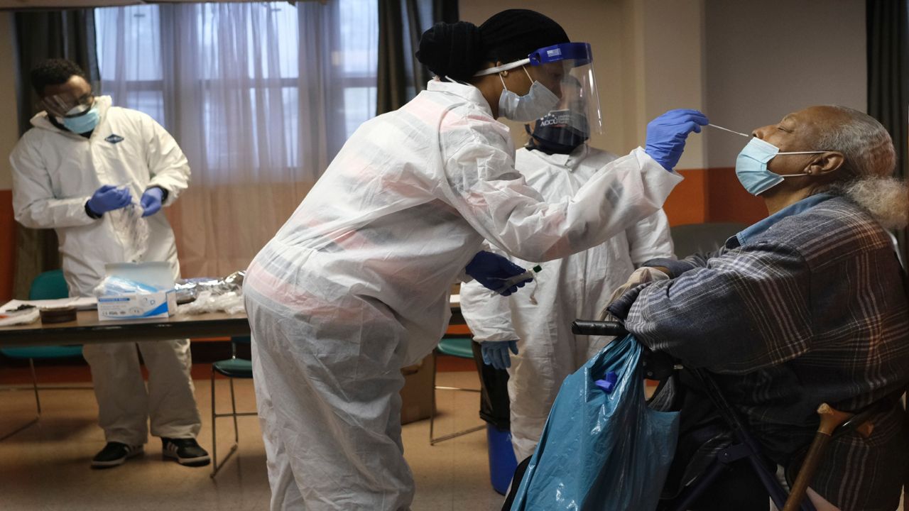 Mary Mack, right, a resident of senior housing, is tested for COVID-19 in Paterson, N.J., Friday, May 8, 2020. New York City is offering to test all nursing home residents and staffers for the coronavirus amid growing scrutiny of outbreaks that have taken more lives in New York than any other state.