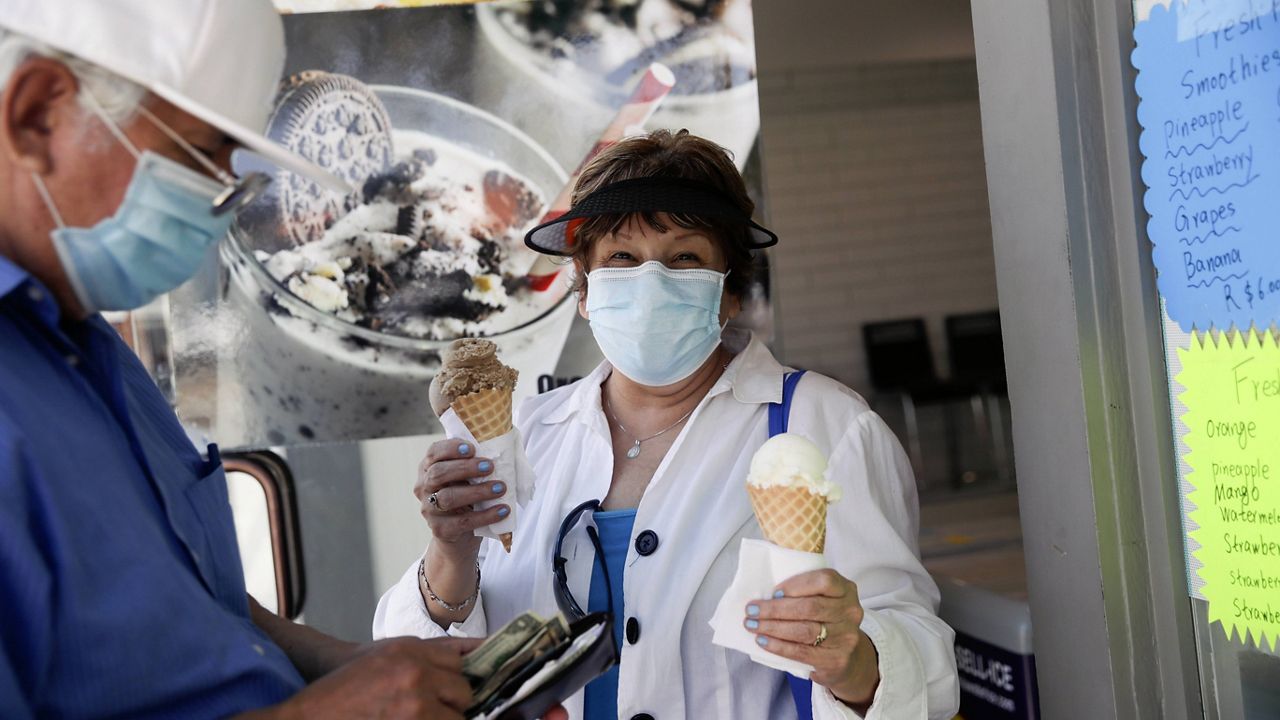 Patrons buy ice cream Sunday, May 24, 2020, on Balboa Island in Newport Beach, Calif. (AP Photo/Marcio Jose Sanchez)