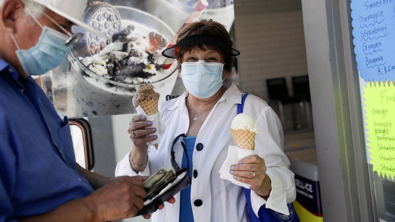 Patrons buy ice cream Sunday, May 24, 2020, on Balboa Island in Newport Beach, Calif. (AP Photo/Marcio Jose Sanchez)