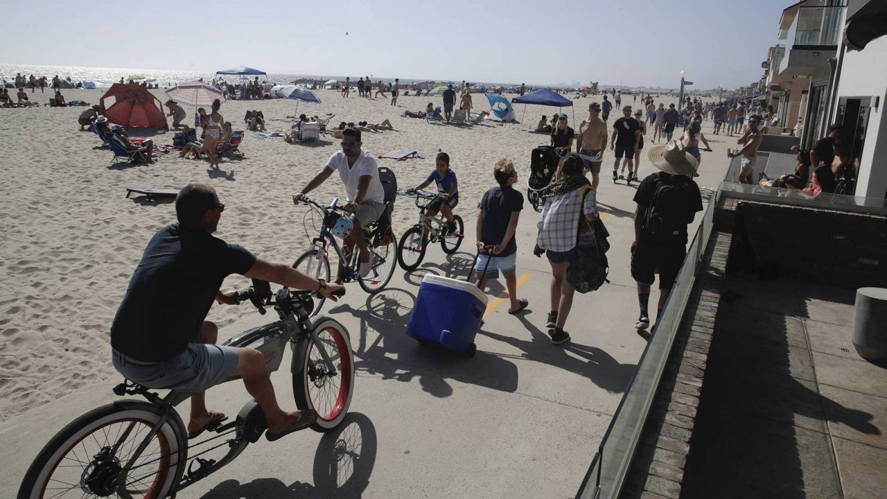 Visitors use a bike and walking path Sunday, May 24, 2020, in Newport Beach, Calif., during the coronavirus outbreak. (AP Photo/Marcio Jose Sanchez)