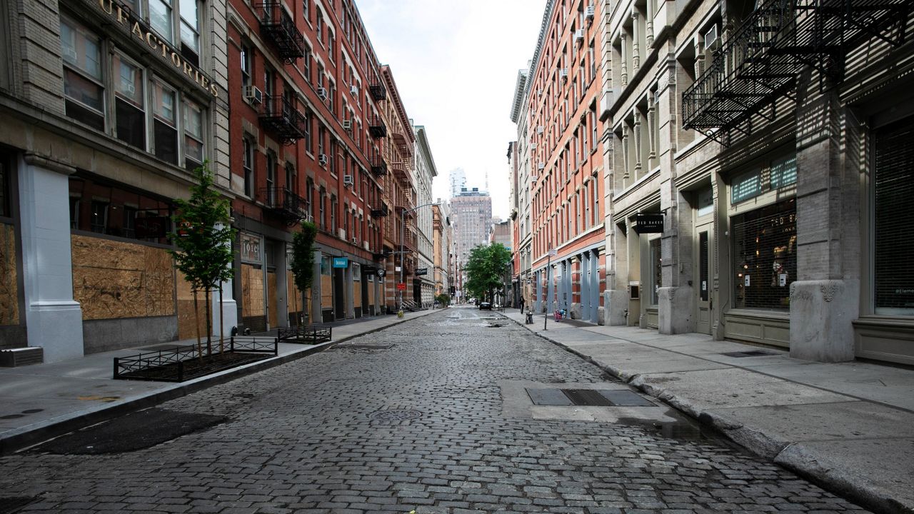 A wide shot of a deserted cobblestoned SoHo street with buildings shown on both sides.