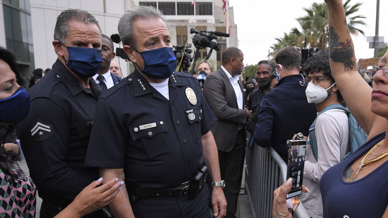 Police chief Michel Moore, center, walks over to protesters to speak to them after a vigil with members of professional associations and the interfaith community at LAPD headquarters, June 5, 2020. (AP Photo/Mark J. Terrill)