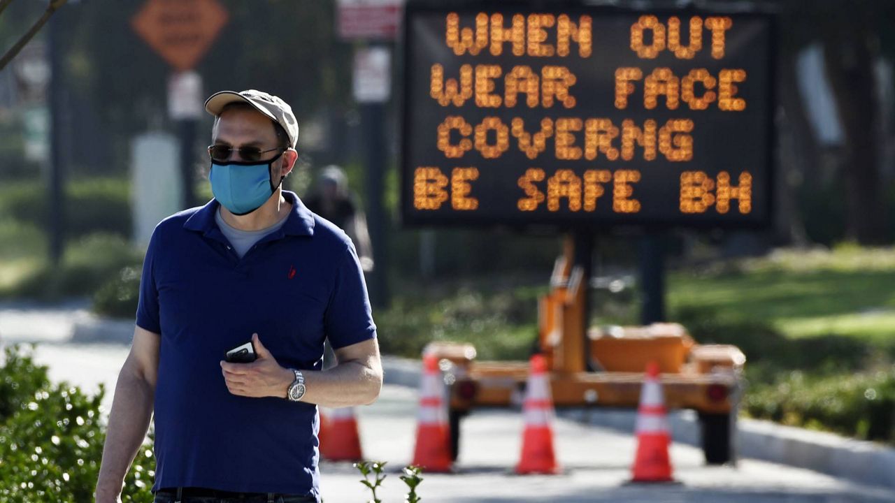 In this April 16, 2020, file photo, an electronic sign on Santa Monica Boulevard reminds people to wear masks to limit the spread of coronavirus in Beverly Hills, Calif. On Sunday, Los Angeles County reported 1,192 new cases of COVID-19 and nine more deaths today, bringing the county's totals to 221,950 cases and 5,254 fatalities. (Chris Pizzello/AP)