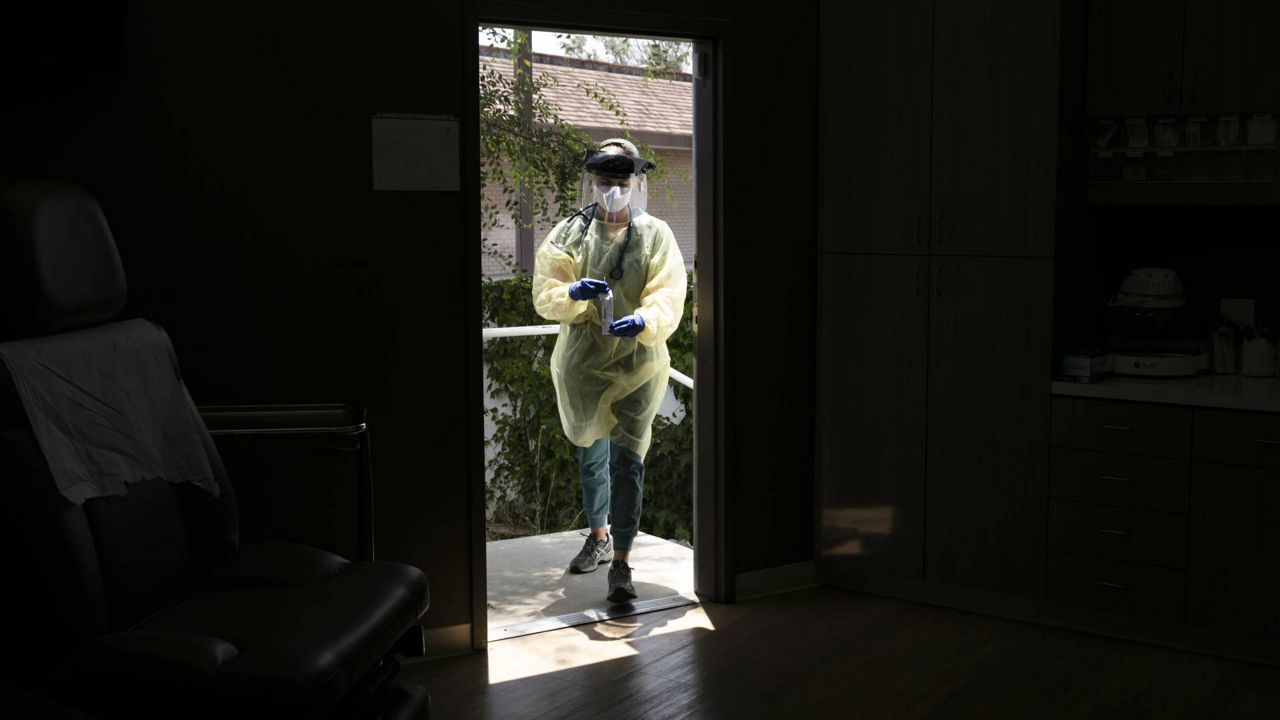 A physician assistant carries a nasal swab sample collected for COVID-19 testing at Xpress Urgent Care June 25, 2020, in Tustin, Calif. (AP/Jae C. Hong)