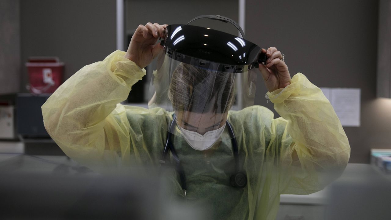 In this June 25, 2020 file photo, a physician assistant takes off her face shield after collecting a nasal swab sample from a patient for COVID-19 testing at Xpress Urgent Care in Tustin, Calif. (AP/Jae C. Hong)