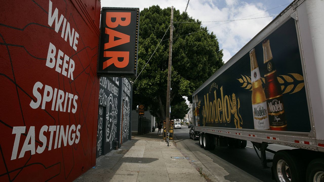 A truck with a beer advertisement stops in front of a bar in Los Angeles, Monday, June 29, 2020. (AP Photo/Jae C. Hong)