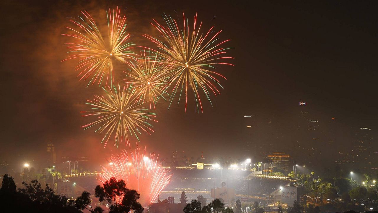 In this July 4, 2019 file photo, fireworks explode over Dodger Stadium with the Los Angeles skyline in the background. (AP Photo/Mark J. Terrill)