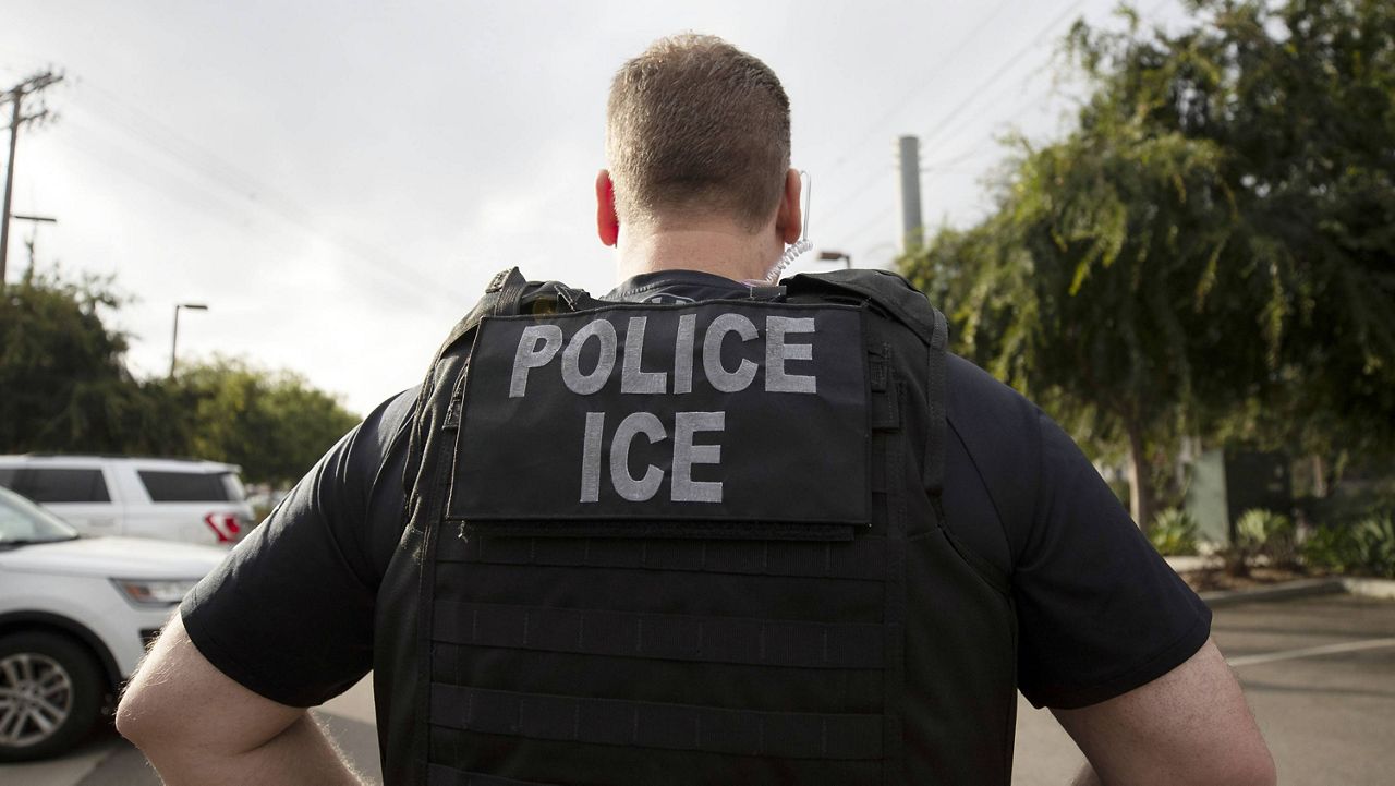 In this July 8, 2019, file photo, a U.S. Immigration and Customs Enforcement (ICE) officer looks on during an operation in Escondido, Calif. (AP Photo/Gregory Bull, File)