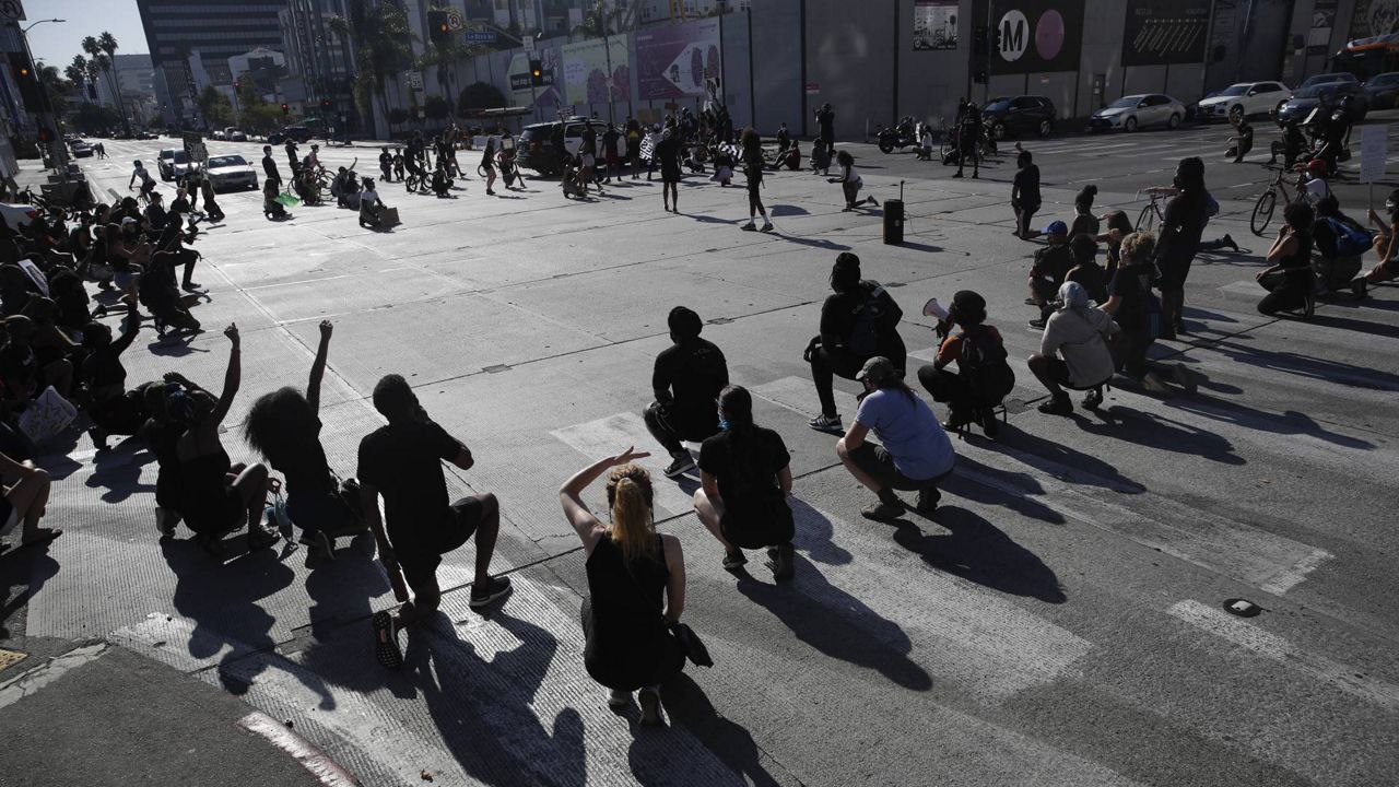 Demonstrators kneel while blocking an intersection during a protest in memory of Breonna Taylor, July 11, 2020, in L.A. (AP/Marcio Jose Sanchez)