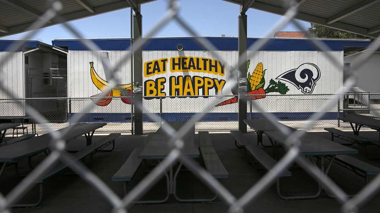 In this July 17, 2020, file photo, the cafeteria area of an elementary school is seen through a fence in Los Angeles. (AP Photo/Jae C. Hong, File)
