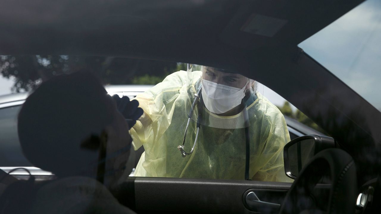 In this June 25, 2020, file photo, physician assistant Nicole Kramer collects a nasal swab sample from a patient for COVID-19 testing in Tustin, Calif., in Orange County. A technical problem has caused a lag in California's tally of coronavirus test results, casting doubt on the accuracy of recent data showing improvements in the infection rate and number of positive cases, and hindering efforts to track the spread, the state's top health official said Tuesday, Aug. 4. (AP Photo/Jae C. Hong, File)