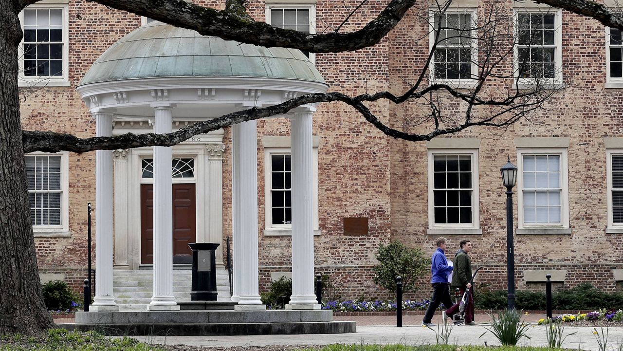 FILE - In this Wednesday, March 18, 2020, file photo, people remove belongings on campus at the University of North Carolina in Chapel Hill, N.C., amid the coronavirus pandemic. The University of North Carolina Chapel Hill announced it has identified two clusters of the coronavirus on campus in its first week of fall classes. 