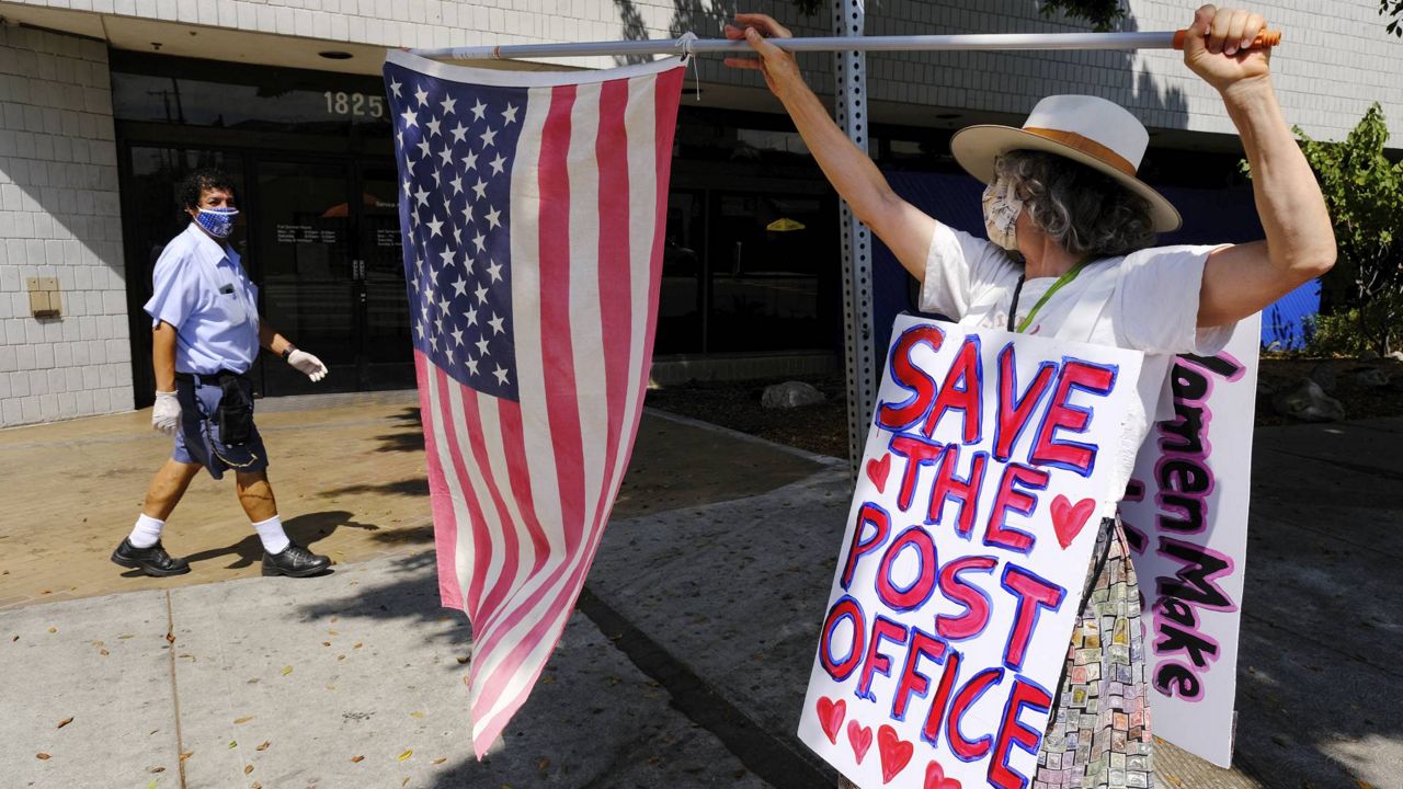 Erica Koesler of Los Angeles demonstrates outside a USPS post office in Los Feliz. A rally was set to begin at 8 a.m. Saturday outside CNN's L.A. bureau. (AP Photo/Chris Pizzello)