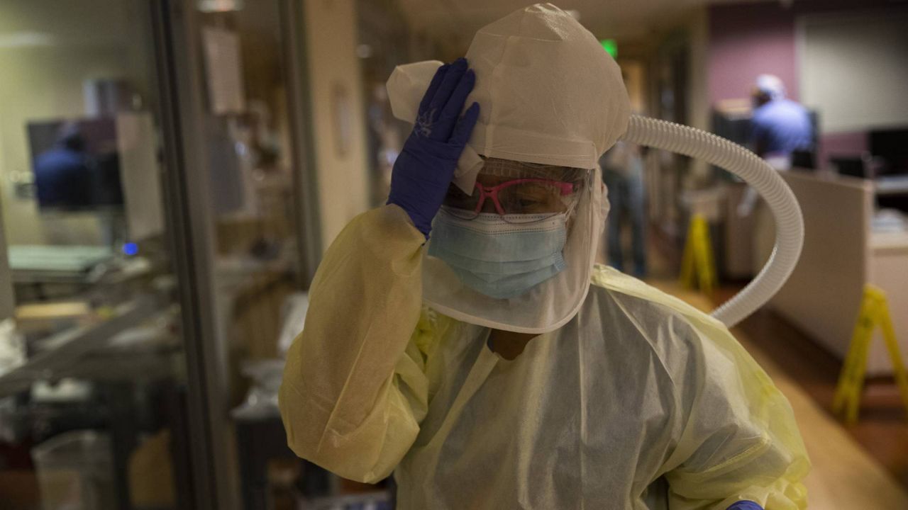 Nurse Shamaine Santos disinfects her respirator using bleach wipes after tending to a COVID-19 patient at St. Jude Medical Center in Fullerton, Calif., July 7, 2020. (AP/Jae C. Hong)