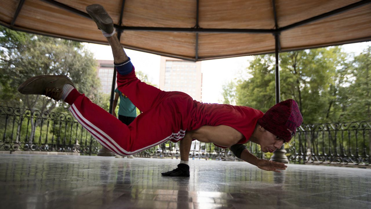 Carlos Cruz, a breakdancer, practices at a kiosk in Alameda park after being closed off to the public for nearly five months due to the new coronavirus pandemic, in Mexico City, Tuesday, Aug. 18, 2020. (AP Photo/Fernando Llano)