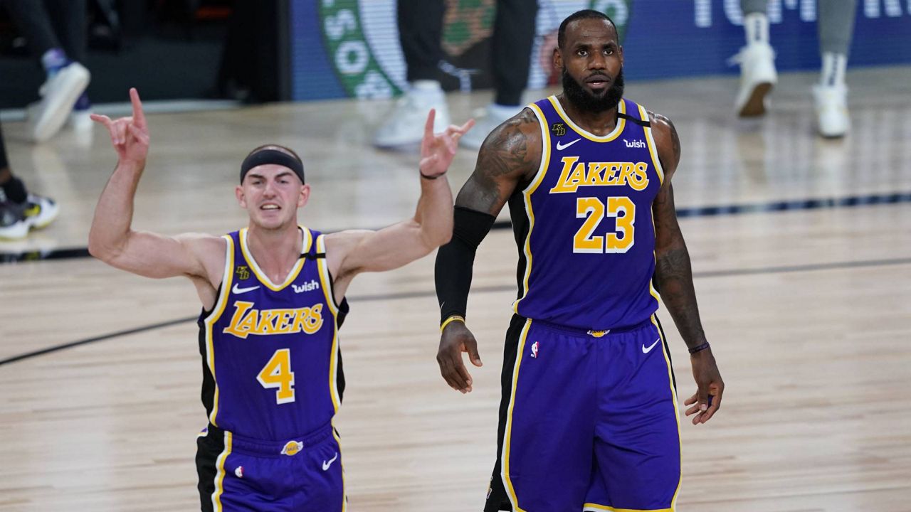 Lakers guard Alex Caruso and LeBron James celebrate their win over the Trail Blazers Saturday. (AP Photo/Ashley Landis, Pool)