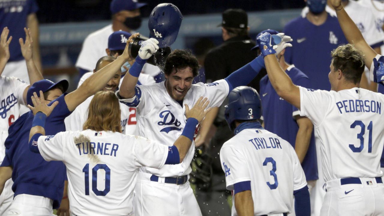 Los Angeles Dodgers' Cody Bellinger is welcomed home by teammates