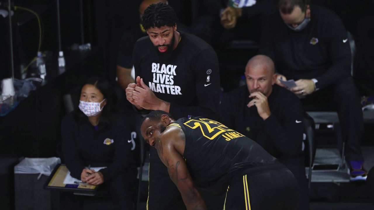Anthony Davis and LeBron James talk in the first half of Game 4 against the Portland Trail Blazers, Monday, August 24, 2020. (Kim Klement/Pool Photo via AP)