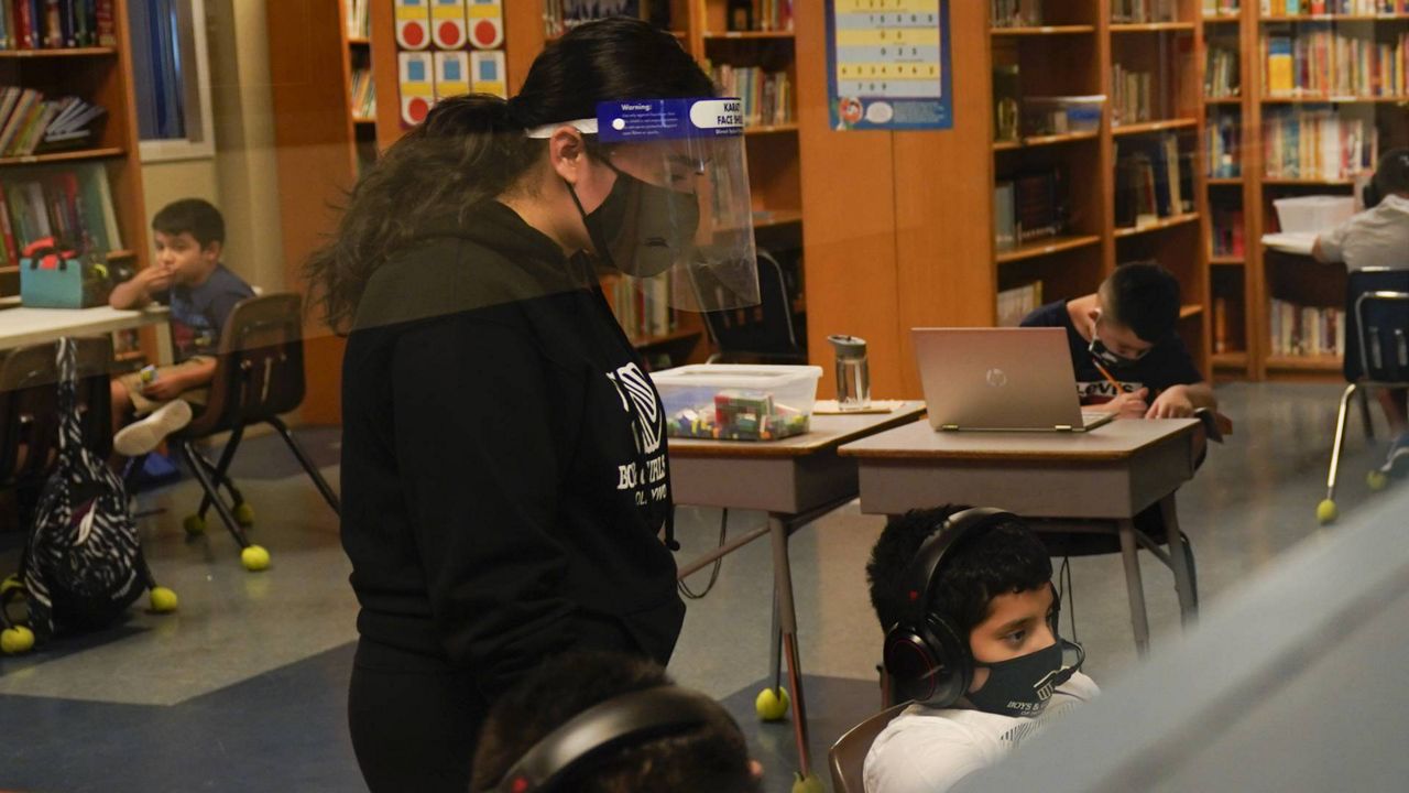 Education Coordinator Madeline Son wears a face shield while helping Los Angeles Unified School District students with their online classes at Boys & Girls Club of Hollywood in LA, Aug. 26, 2020. (AP Photo/Jae C. Hong)